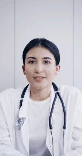 A female doctor in a white coat and stethoscope, providing medical care remotely through telehealth.