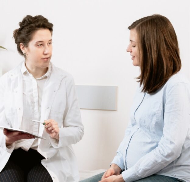 A woman converses with a doctor as another woman sits on a bed at Renewed Light Mental Health Care.