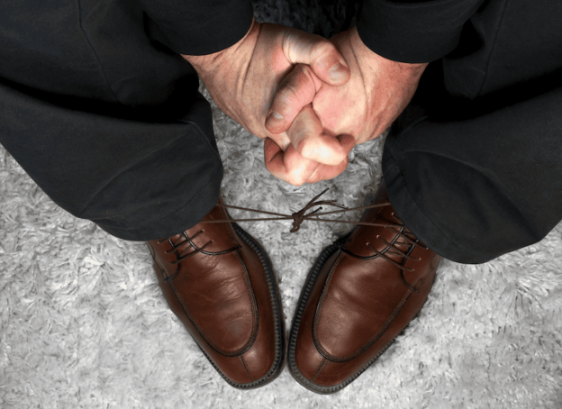 A pair of brown shoes on the feet of an elderly man, illustrating senior anxiety.